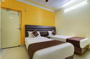 パトナーにあるHOTEL GARDEN VILLAのベッド2台とドアが備わるホテルルームです。