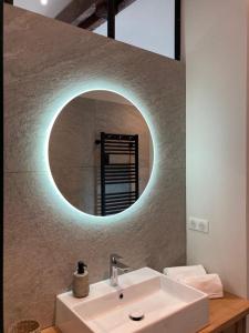 bagno con lavandino bianco e specchio di Domaine Jacqueline Père & Filles ad Aix-les-Bains