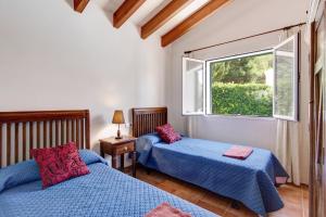 a bedroom with two beds and a window at Villa Menorca Juanita by Mauter Villas in Cala en Blanes +33 photos