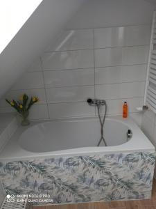 a bath tub with a faucet in a bathroom at Domek Całoroczny Pod Dworem in Wola Kalinowska