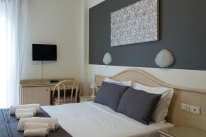 sypialnia z łóżkiem i biurkiem z telewizorem w obiekcie Hotel Airone w Bibione