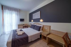 1 dormitorio con cama y banco. en Hotel Airone en Bibione