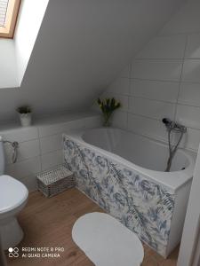 a bathroom with a bath tub and a toilet at Domek Całoroczny Pod Dworem in Wola Kalinowska