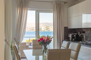 una cucina e una sala da pranzo con vista sull'oceano di Villa Palace Al Nera a Trogir
