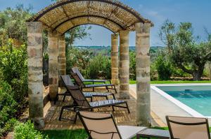 an outdoor patio with chairs and a swimming pool at Villa Torre Dell'Altomare con piscina, blocco n2 - Apulia Home in Alliste