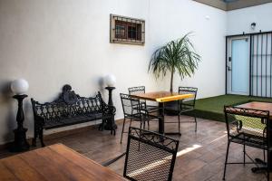 a room with a table and chairs and a bench at Hoteles ANTIGUA - SANTA LUCIA MTY in Monterrey