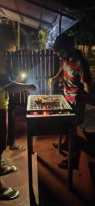 a person sitting at a table in front of a table with food at SAVITHRI Inn COTTAGE in Varkala