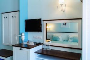 a small room with a bed and a mirror at Hotel Evridika in Nesebar