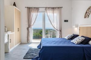 a bedroom with a blue bed and a large window at Villa Torre Dell'Altomare con piscina, blocco n2 - Apulia Home in Alliste +38 photos