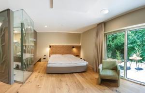 a bedroom with a bed and a glass shower at Hotel Weiherhof am Golfpark in Wadern