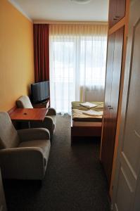 a hotel room with a couch and a bed at AGIS Pokoje Gościnne in Gdańsk