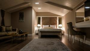 a bedroom with a bed and a couch and a table at BANDIRMA PALAS OTEL in Bandırma