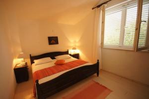 een slaapkamer met een bed en een groot raam bij Apartments Viganj (22) in Viganj