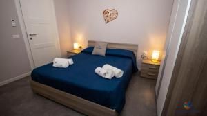 a bedroom with a blue bed with towels on it at Gioia del Mare in Il Monte