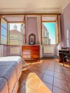 a bedroom with a bed and two windows at Emerald Palace in Florence