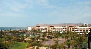 阿加迪爾的住宿－Hotel Riu Palace Tikida Agadir - All Inclusive，享有带游泳池和棕榈树的度假村的正面景色