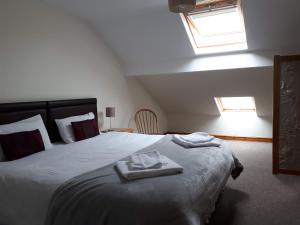 a bedroom with a large bed with two towels on it at Gwilym's Stable in Builth Wells