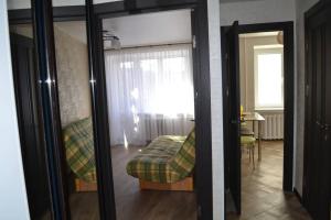a mirror in a room with a couch and a window at Apartment Brooklyn in Kamianets-Podilskyi in Kamianets-Podilskyi