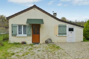 una pequeña casa blanca con ventanas verdes y una puerta en Maison de 2 chambres avec jardin clos et wifi a Villenauxe la Grande, en Villenauxe-la-Grande