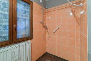 a bathroom with an orange tiled shower with a window at Maison charmante à Villenauxe in Villenauxe-la-Grande +14 photos