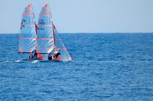 two people on a sail boat in the water at B & B Villa Flora in Mondello