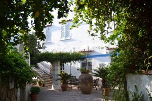 a white house with potted plants in a courtyard at Piccolo Tirreno Hotel Residence in Procida