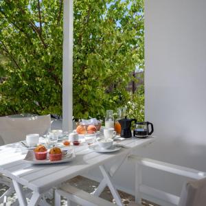 a white table with muffins and cupcakes on it at Mirabeli Apartments & Suites in Pollonia