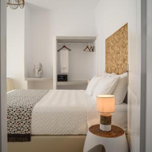 a bedroom with a bed and a table with a lamp at Mirabeli Apartments & Suites in Pollonia