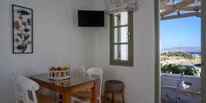 a dining room with a table and chairs and a window at Mirabeli Apartments & Suites in Pollonia