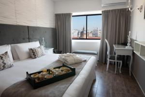 Una habitación de hotel con una cama con una bandeja de donuts. en Ker San Telmo Hotel en Buenos Aires