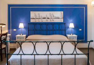 a blue bedroom with a bed and two lamps at B&B San Trifone in Adelfia +65 photos
