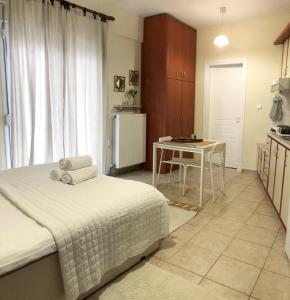 a bedroom with a bed and a table and a kitchen at Stergios_Apartments 03 in Kozani