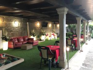 a patio with a table and chairs and a couch at Hotel Playa Samil Vigo in Vigo