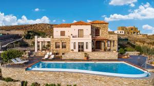 a villa with a swimming pool in front of a house at Villa Selini in Kouroúpi