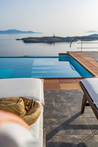 a swimming pool with a bed next to the water at Villa Selini in Kouroúpi