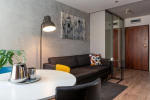 salon z kanapą i stołem w obiekcie apartamenty-wroc Golden House we Wrocławiu