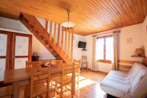 a dining room with a table and a wooden ceiling at Appartement de 2 chambres avec jardin et wifi a Arvieux a 1 km des pistes in Arvieux