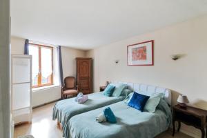 1 Schlafzimmer mit 2 Betten und blauen Kissen in der Unterkunft Maison de 2 chambres avec terrasse et wifi a Ornans in Ornans