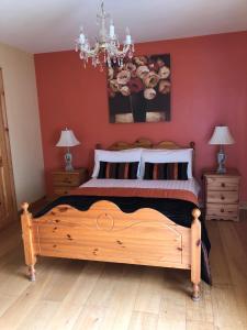 una camera con letto in legno e parete rossa di The Annex a Ardara