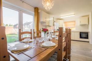 uma sala de jantar com uma mesa com pratos e copos em Beautiful Character Home, Parking Garden WiFi Self Check-in em Luton