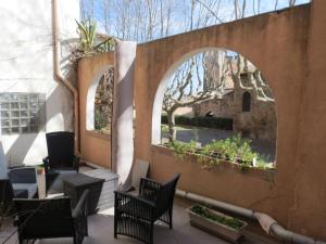 um pátio exterior com cadeiras e plantas num arco em Appartement avec jardin privatif em Fréjus