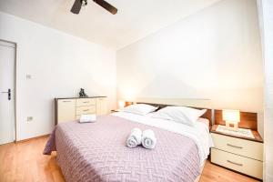Un dormitorio con una cama con dos zapatos blancos. en Apartman Andrej, en Povlja