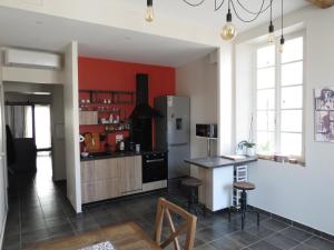 uma cozinha com um frigorífico e um balcão com bancos em Appartement avec jardin privatif em Fréjus