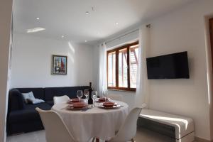 una sala de estar con una mesa y un sofá en Villa NEDE, en Podgora