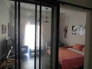 sypialnia z łóżkiem i przesuwnymi szklanymi drzwiami w obiekcie Appartement avec jardin privatif w Fréjus