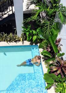 a woman is floating in a swimming pool at Bona Vida Hostel in Ríohacha