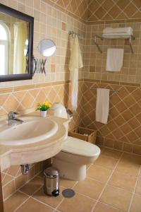 bagno con lavandino, servizi igienici e specchio di Villa Delhi by Privilege Bay a La Oliva