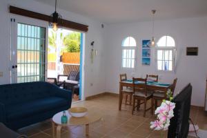 ラ・オリーバにあるVilla Delhi by Privilege Bayの青いソファとテーブルのあるリビングルーム