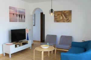 ラ・オリーバにあるVilla Delhi by Privilege Bayの椅子2脚とテレビのあるリビングルーム