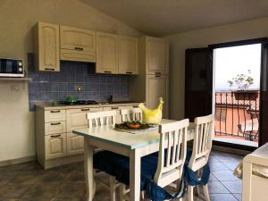 a kitchen with a table and chairs and a kitchen with a balcony at Sas Tilibbas-Ammentos Posada in Posada
